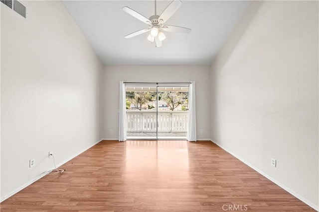 unfurnished room with baseboards, wood finished floors, visible vents, and ceiling fan