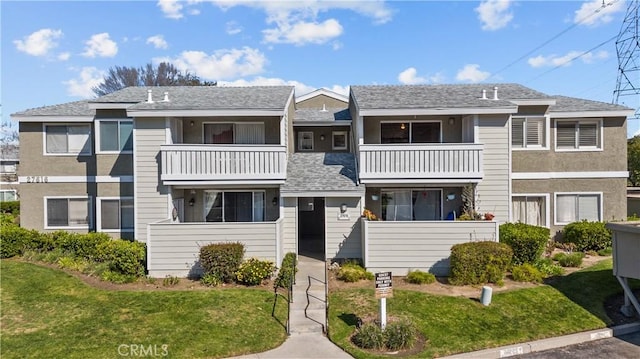 townhome / multi-family property featuring a front yard and a balcony