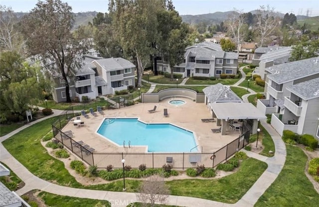 pool with a patio area, a residential view, and fence