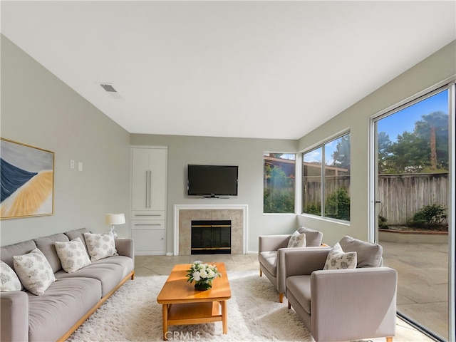 living area with light tile patterned floors, visible vents, and a tiled fireplace