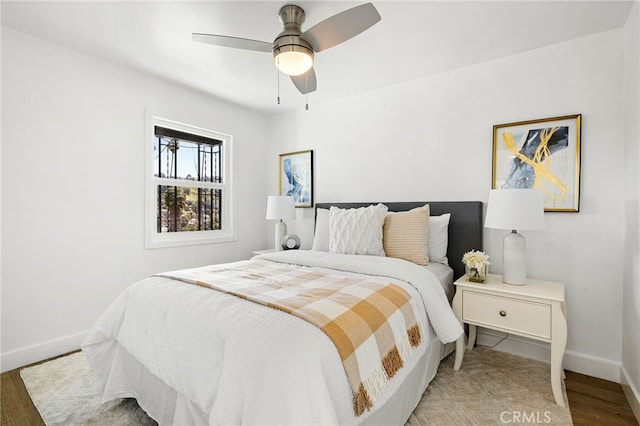 bedroom with baseboards, light wood-style floors, and a ceiling fan