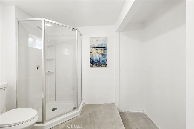 bathroom with unfinished concrete flooring, toilet, and a shower stall