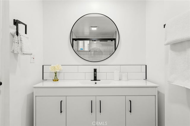 bathroom featuring vanity and tasteful backsplash