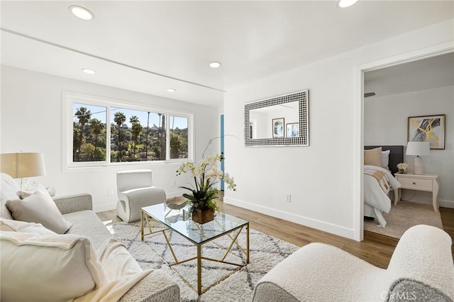 living area with recessed lighting, wood finished floors, and baseboards