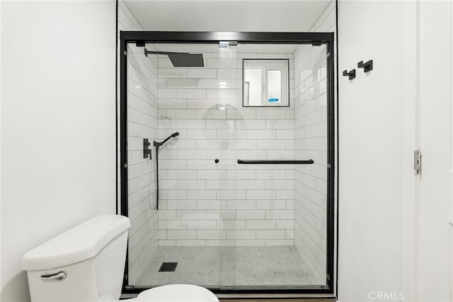 bathroom featuring a stall shower and toilet