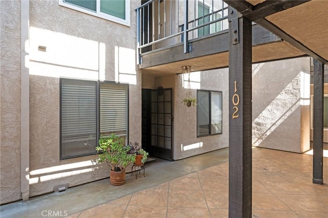 doorway to property featuring a patio area and stucco siding