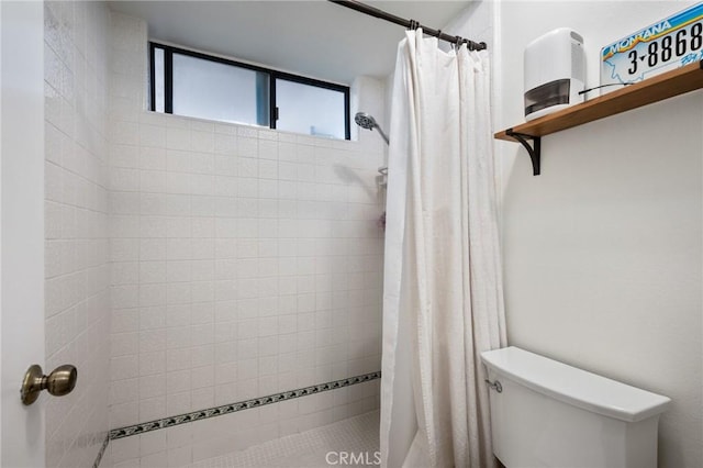full bathroom with toilet and a tile shower