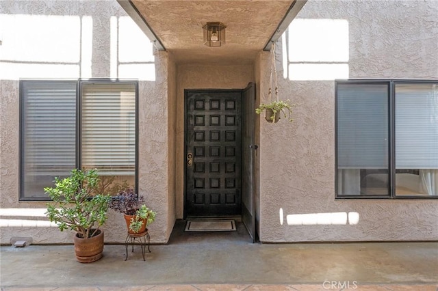 doorway to property featuring stucco siding