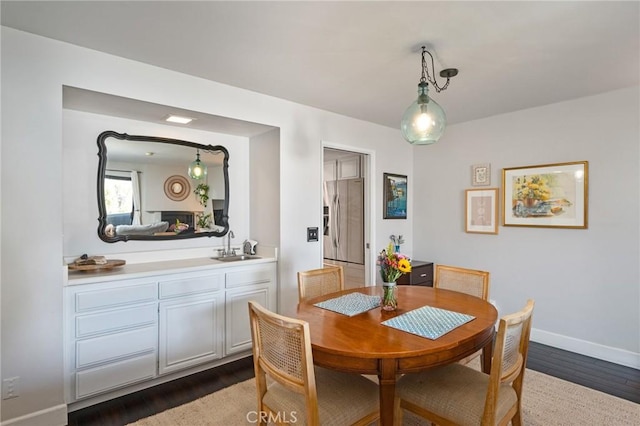 dining room featuring dark wood-type flooring and baseboards