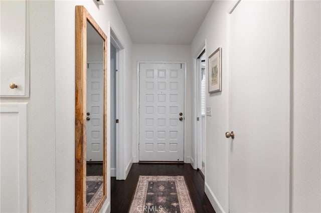 hall featuring baseboards and dark wood finished floors