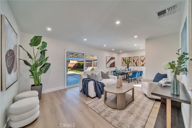 living area featuring light wood-style flooring, baseboards, visible vents, and recessed lighting