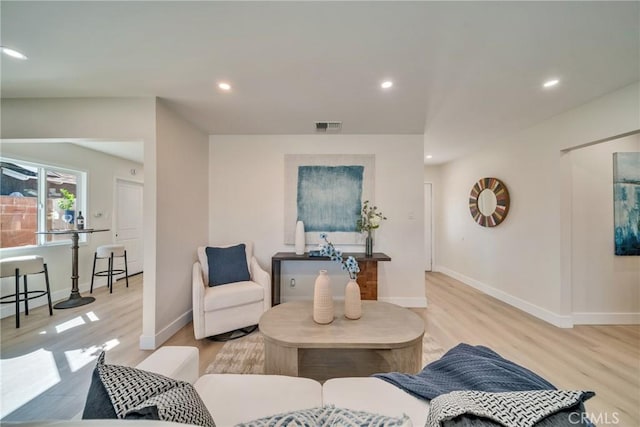 living area featuring light wood finished floors, baseboards, visible vents, and recessed lighting