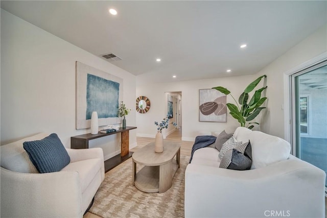 living area with recessed lighting, visible vents, light wood-type flooring, and baseboards