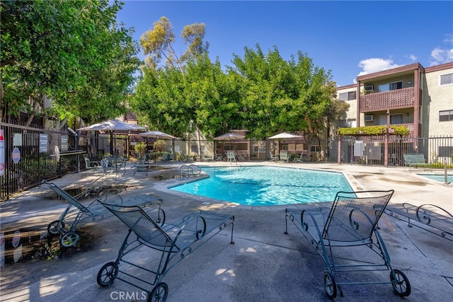 community pool featuring a patio area and fence