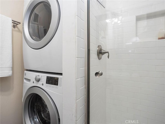 clothes washing area featuring laundry area and stacked washer and clothes dryer