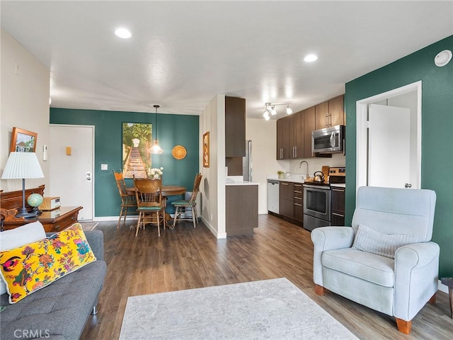 living room with recessed lighting, baseboards, and dark wood-style flooring