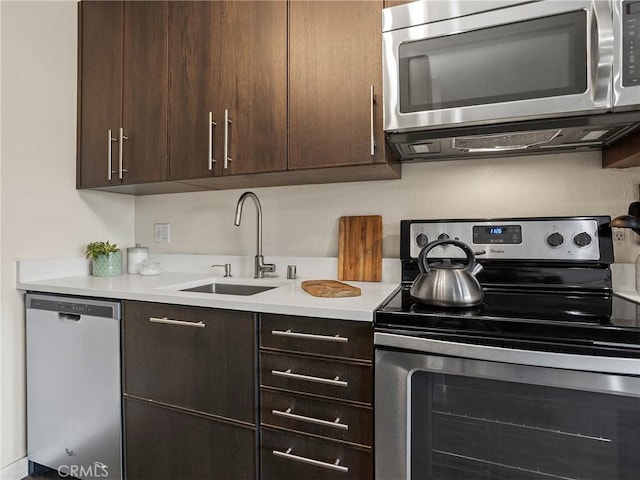 kitchen featuring light countertops, dark brown cabinets, appliances with stainless steel finishes, and a sink