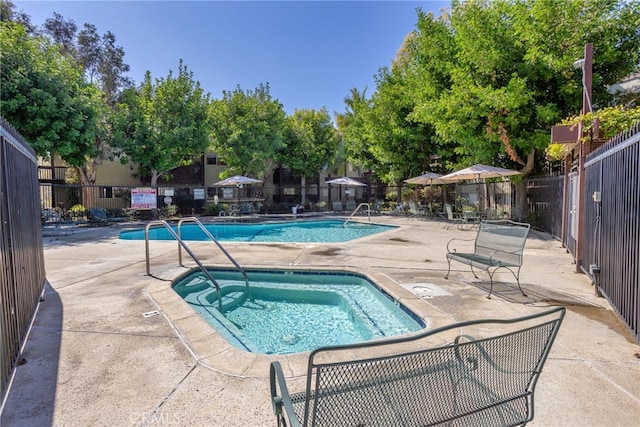 pool featuring a patio, a community hot tub, and fence