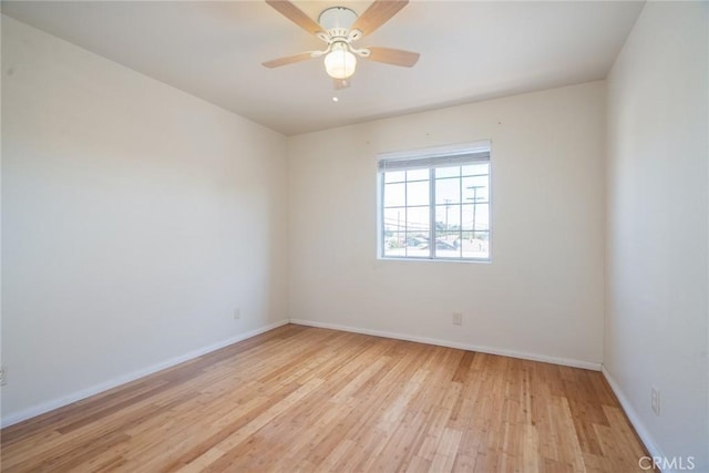 unfurnished room with baseboards, light wood-style floors, and a ceiling fan