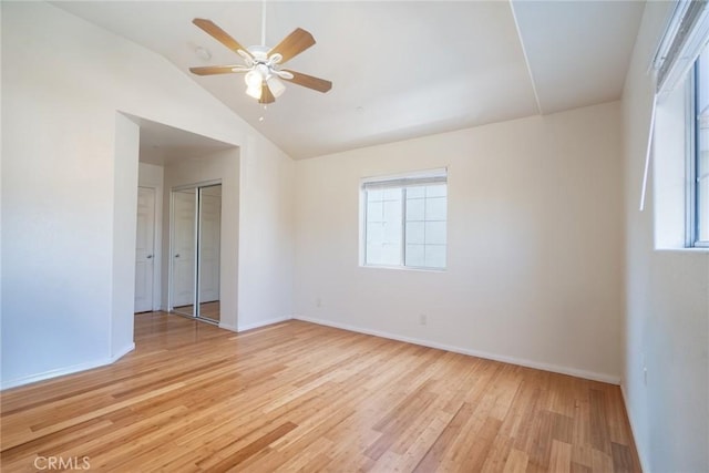 unfurnished room featuring ceiling fan, baseboards, light wood-type flooring, and lofted ceiling