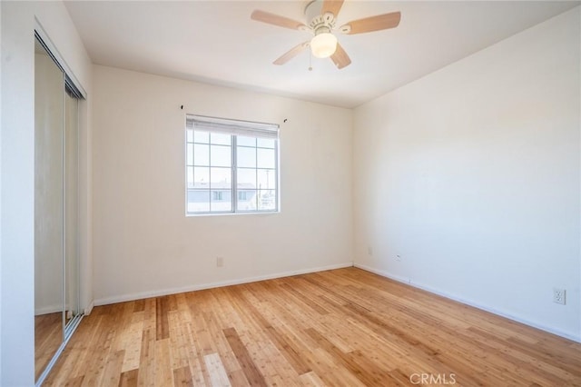 empty room featuring baseboards, ceiling fan, and light wood finished floors