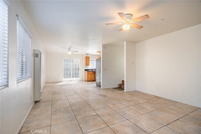 unfurnished room with light tile patterned floors, stairs, and a ceiling fan