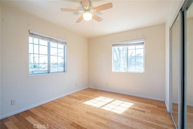 unfurnished bedroom featuring a closet, light wood-style flooring, baseboards, and ceiling fan