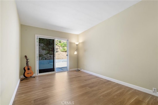 empty room with baseboards and wood finished floors