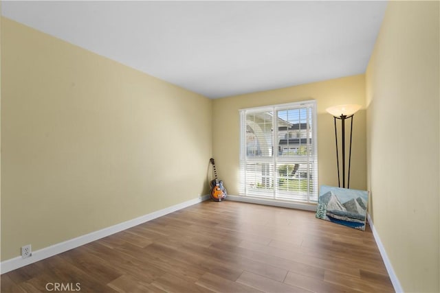 empty room with baseboards and wood finished floors