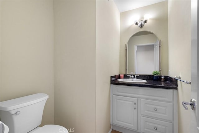 half bathroom featuring toilet and vanity