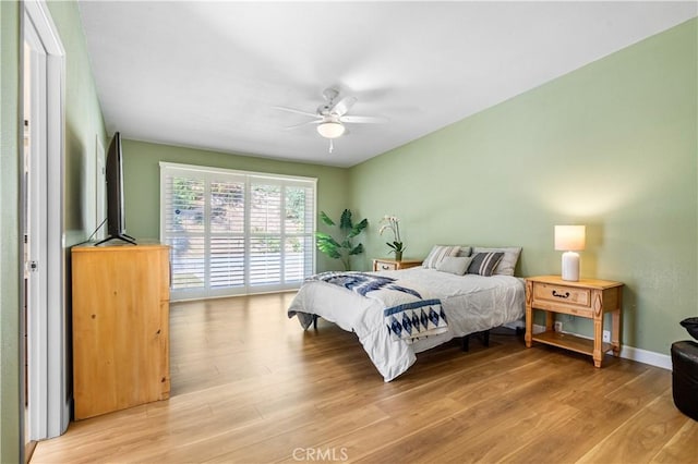 bedroom featuring light wood-type flooring, baseboards, a ceiling fan, and access to outside