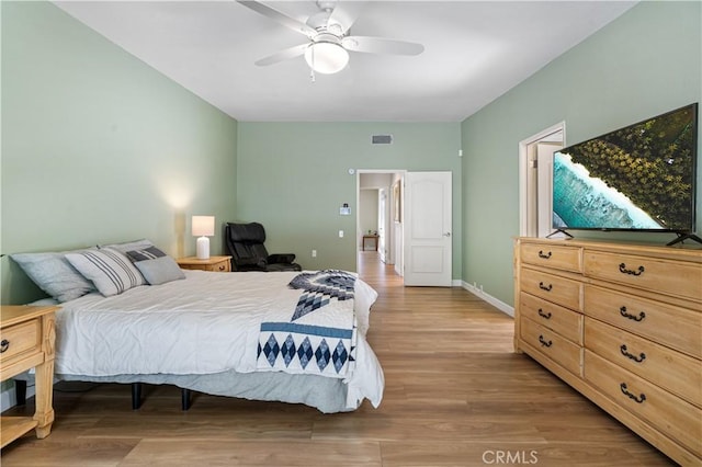 bedroom with ceiling fan, wood finished floors, visible vents, and baseboards