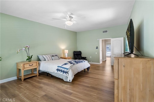 bedroom with visible vents, baseboards, and wood finished floors