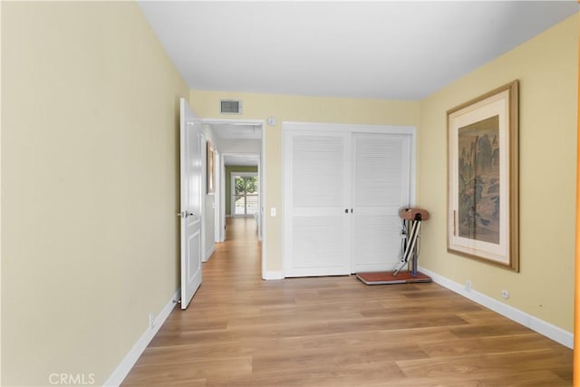 interior space with visible vents, baseboards, a closet, and light wood-style flooring