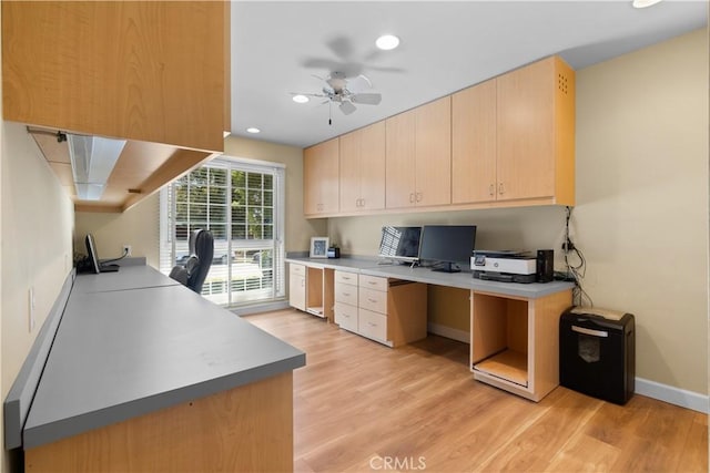 kitchen featuring light brown cabinets, baseboards, built in study area, recessed lighting, and light wood-style floors