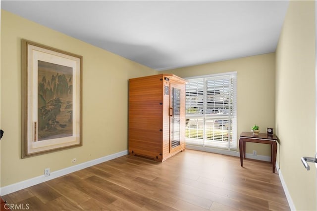 empty room with baseboards and wood finished floors