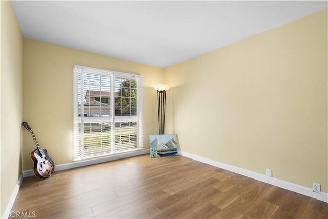 empty room with wood finished floors and baseboards