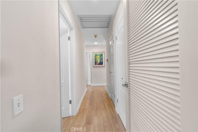 corridor featuring baseboards and light wood-type flooring