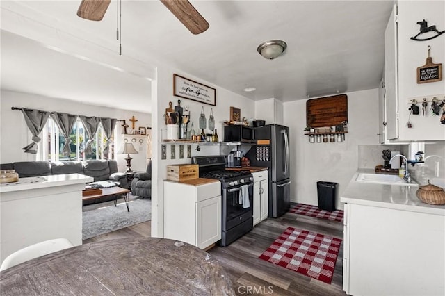 kitchen with a sink, dark wood-type flooring, white cabinetry, and stainless steel appliances