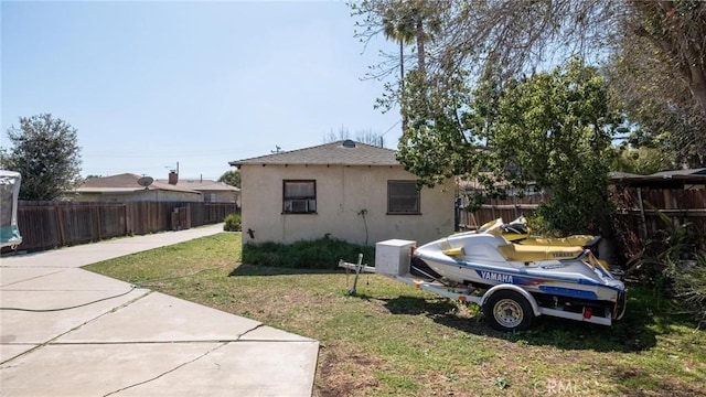 view of side of home featuring a yard, fence private yard, and stucco siding