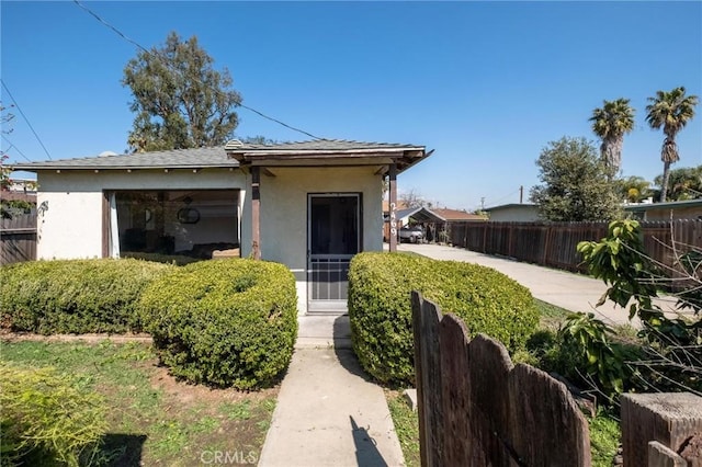 bungalow with fence and stucco siding