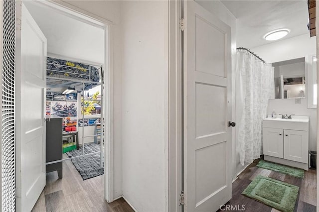 bathroom featuring curtained shower, wood finished floors, and vanity