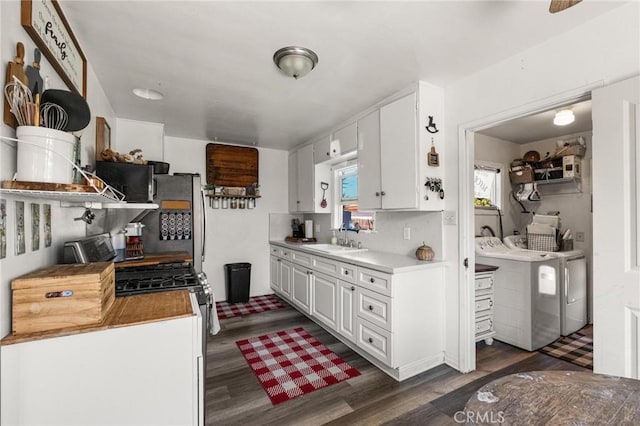 kitchen with a sink, dark wood finished floors, white cabinets, stainless steel appliances, and open shelves