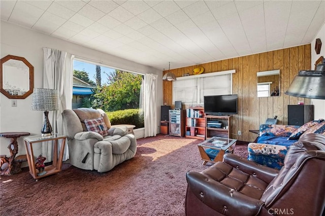 living room with carpet floors and wooden walls