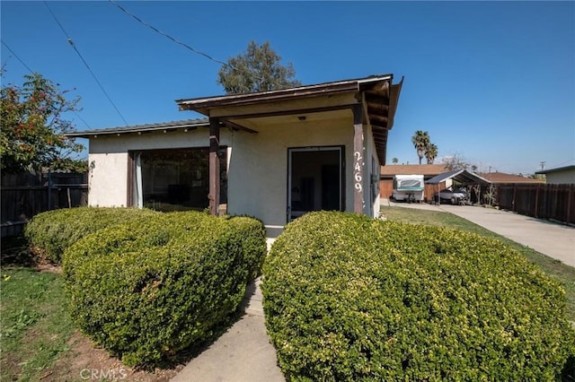 view of front of house featuring stucco siding and fence