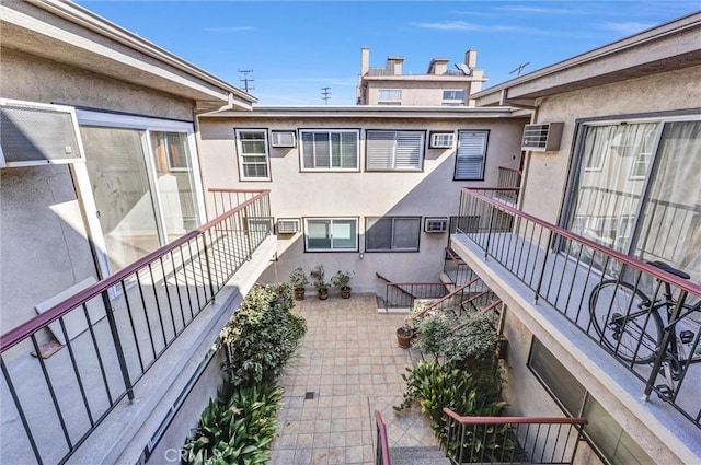 balcony with a wall mounted AC and stairway