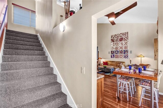 stairway with wood finished floors and baseboards