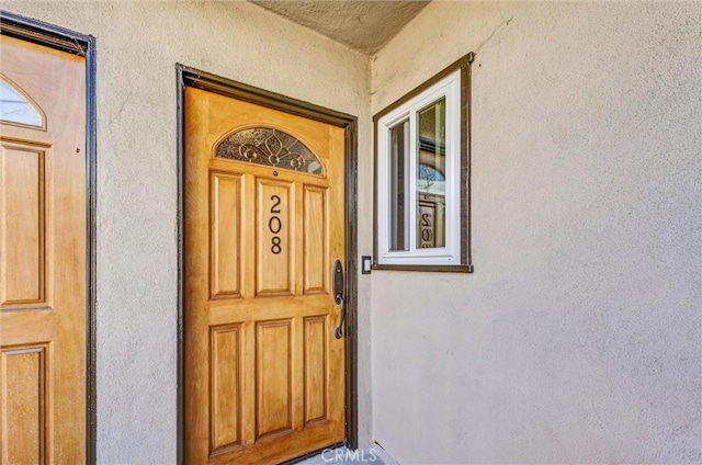 entrance to property featuring stucco siding