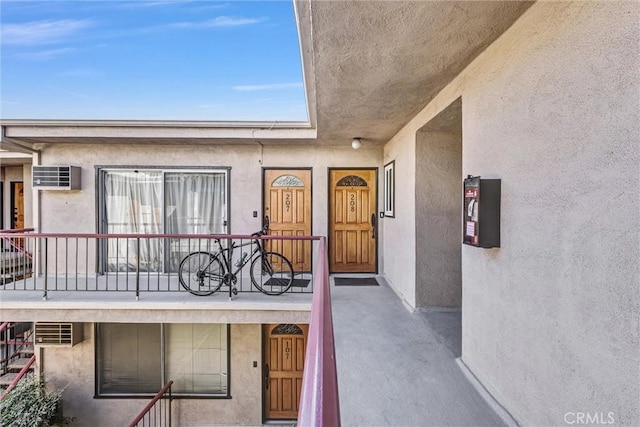 entrance to property featuring stucco siding and a balcony