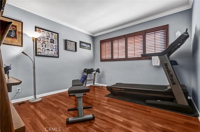 exercise room with wood finished floors, baseboards, and ornamental molding